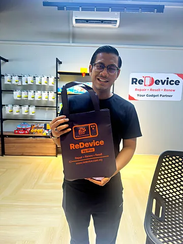 Pelanggan berkaca mata memegang beg ReDevice di kedai