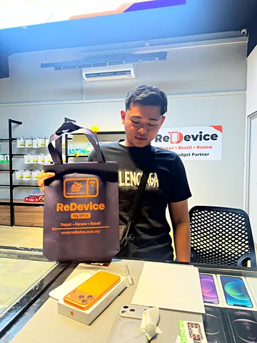 Pelanggan dengan beg ReDevice dan iPhone di kaunter