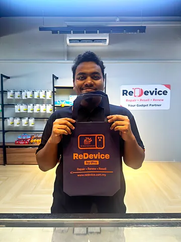 Pelanggan memegang beg ReDevice di hadapan rak aksesori