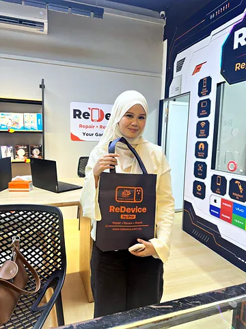Pelanggan bertudung putih memegang beg ReDevice di kedai