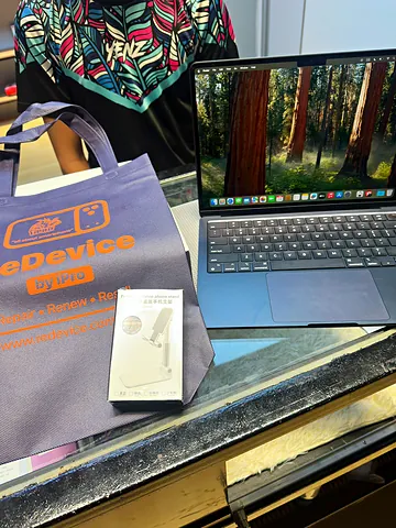 MacBook, kotak aksesori dan beg ReDevice di atas kaunter